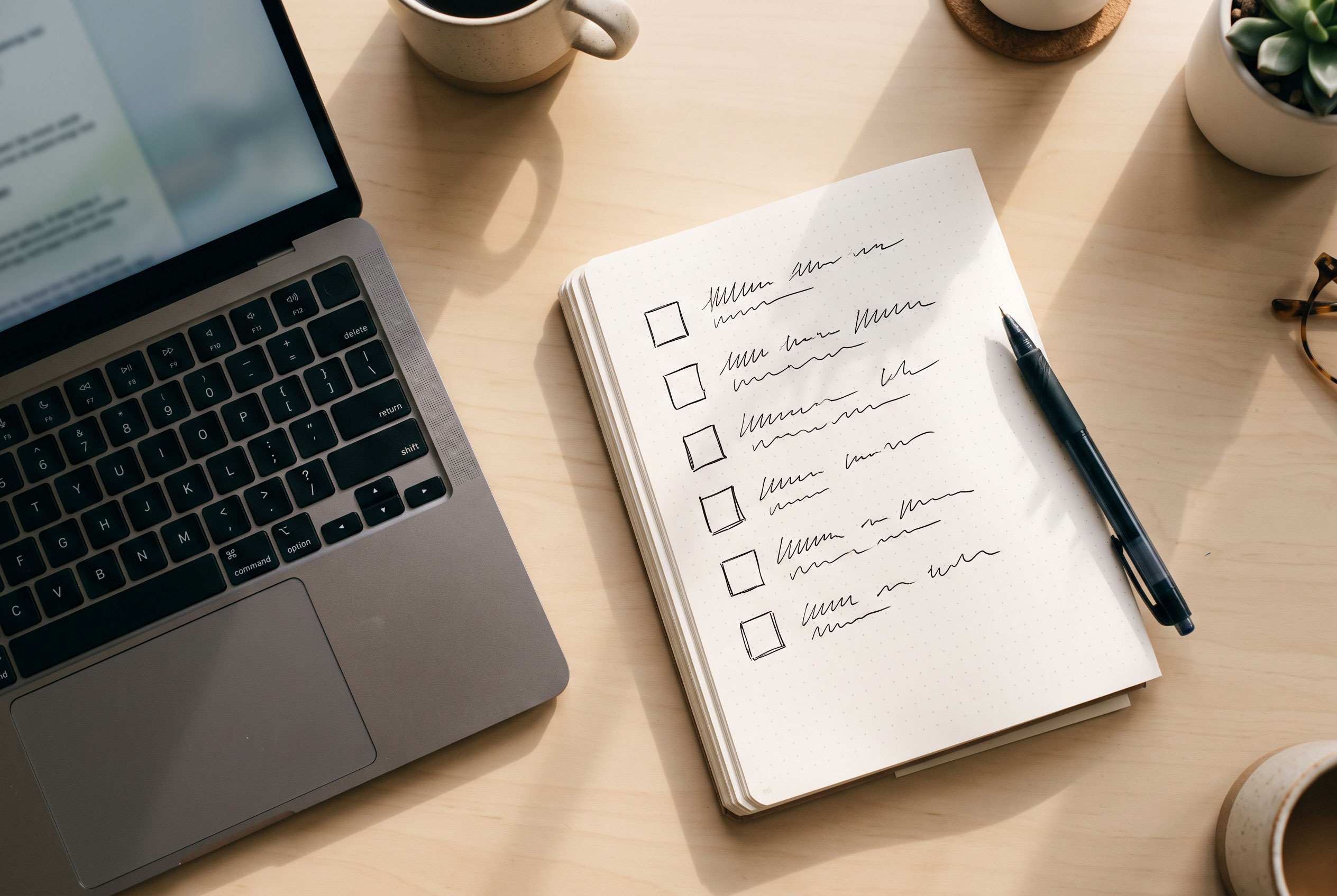 Desk with laptop and handwritten checklist for improving a business website